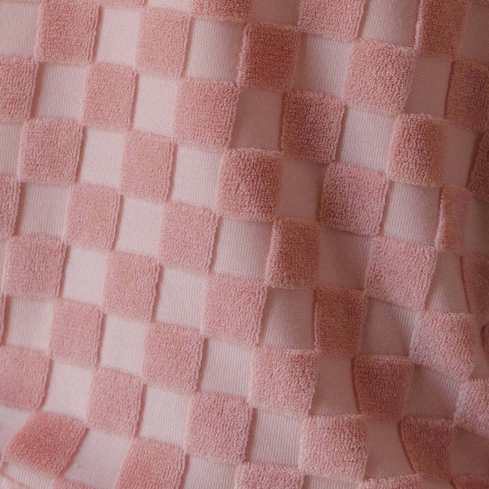 Close-up of the forever french baby Child Terry Short Set in Sea Pink, showing a checkerboard pattern with alternating matte and plush velvety squares. The textured fabric is perfect for family matching outfits or your child's summer look.
