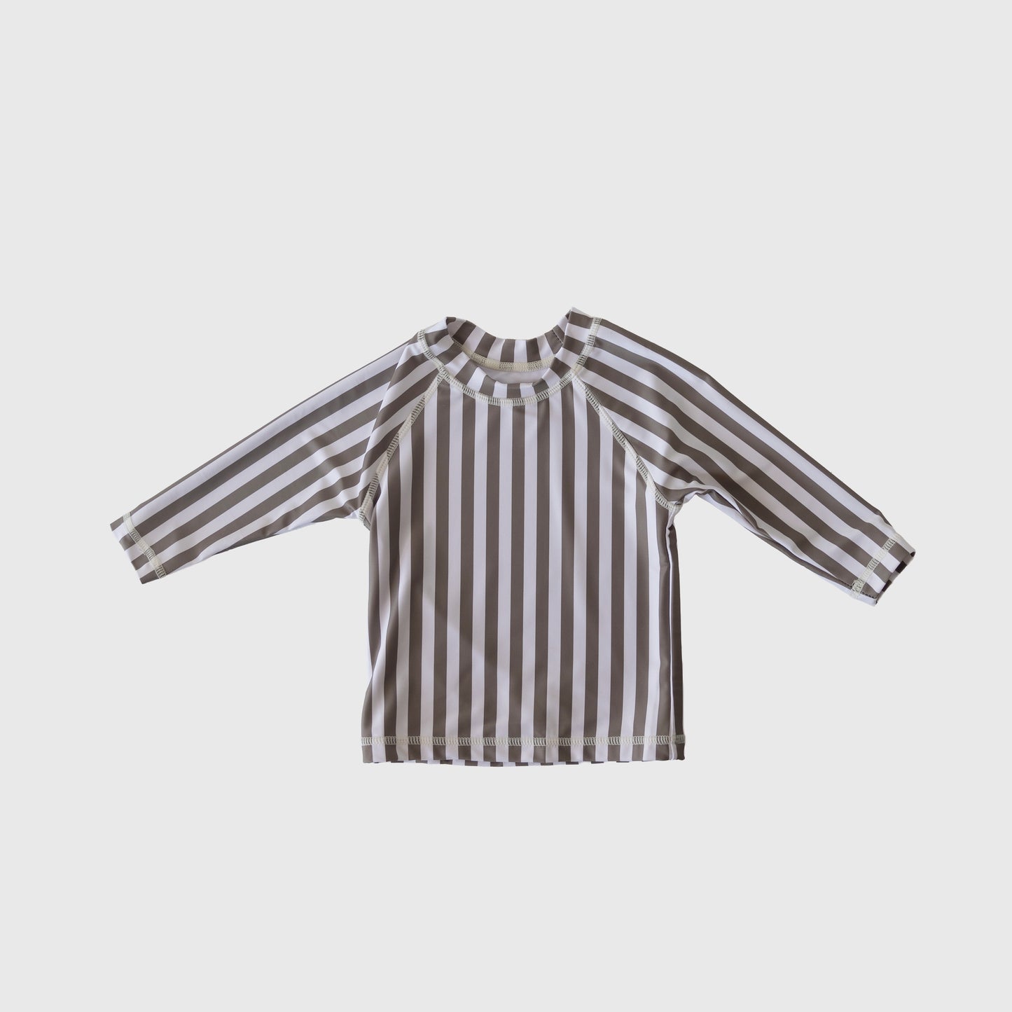 The forever french baby Child Rash Guard | Olive Stripe features long sleeves and vertical brown and white stripes, shown flat on a light gray background—ideal for stylish kids' swimwear adventures.