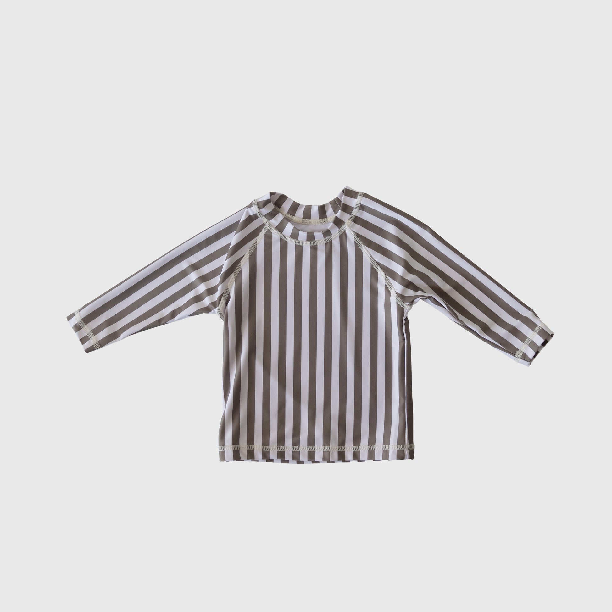 The forever french baby Child Rash Guard | Olive Stripe features long sleeves and vertical brown and white stripes, shown flat on a light gray background—ideal for stylish kids' swimwear adventures.