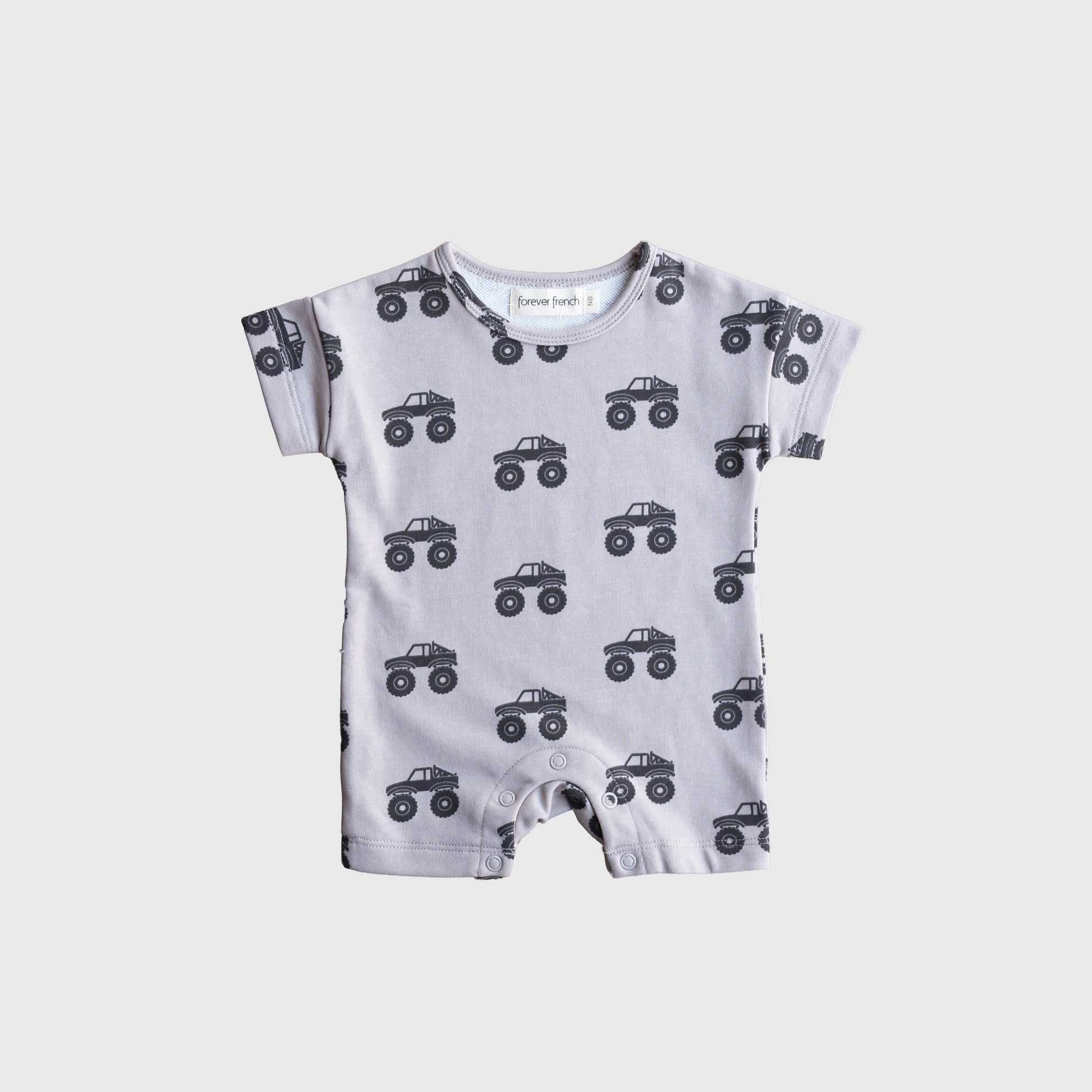 The forever french baby French Terry Romper | Monster Truck is a light gray, short-sleeve romper featuring a black monster truck print, providing breathable comfort for babies and shown flat on a white background.