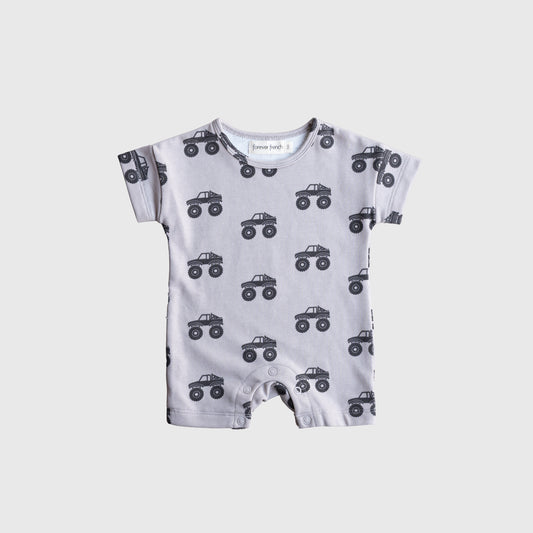 The forever french baby French Terry Romper | Monster Truck is a light gray, short-sleeve romper featuring a black monster truck print, providing breathable comfort for babies and shown flat on a white background.