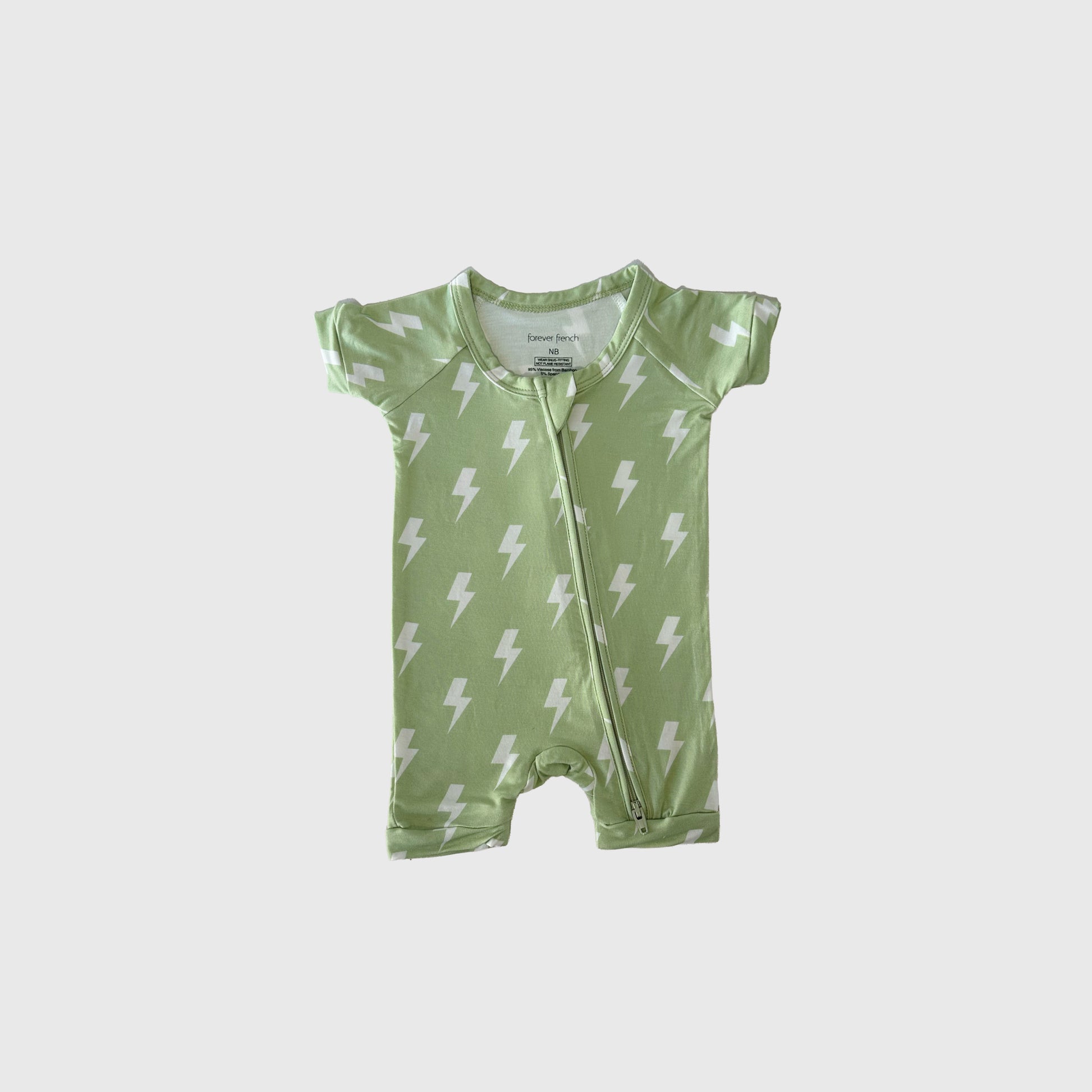 The forever french baby Shortie Bamboo Zip | Flash is a short-sleeved, light green hypo-allergenic bamboo romper for babies with a white lightning bolt pattern and diagonal neck-to-leg zipper, shown on a plain white background.