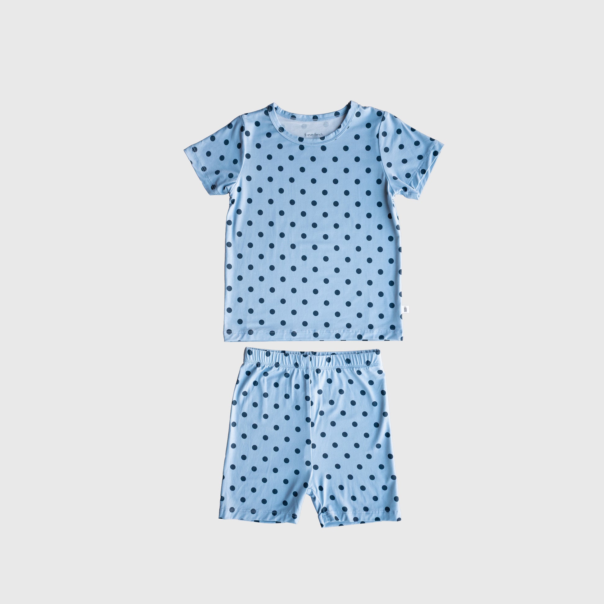 The Bamboo Short Set | Sully by forever french baby features a light blue short-sleeved shirt and matching shorts with black polka dots, crafted from breathable bamboo sleepwear fabric and displayed flat on a plain white background.