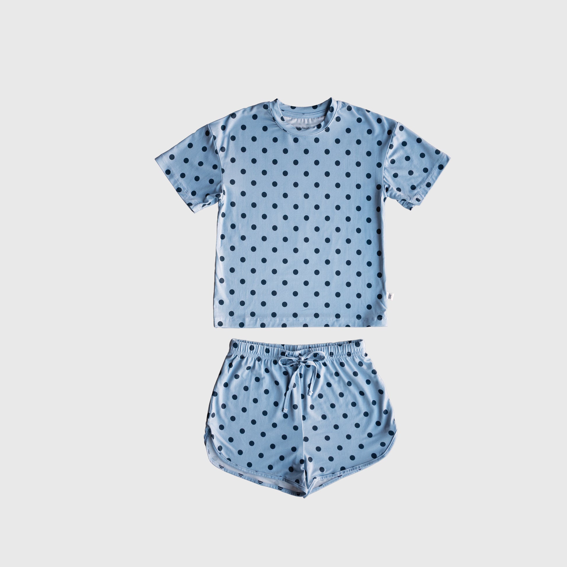 The Girl's Bamboo Short Set | Sully by forever french baby features a blue short-sleeve shirt and matching shorts with black polka dots, crafted from breathable bamboo fabric and displayed on a plain white background.