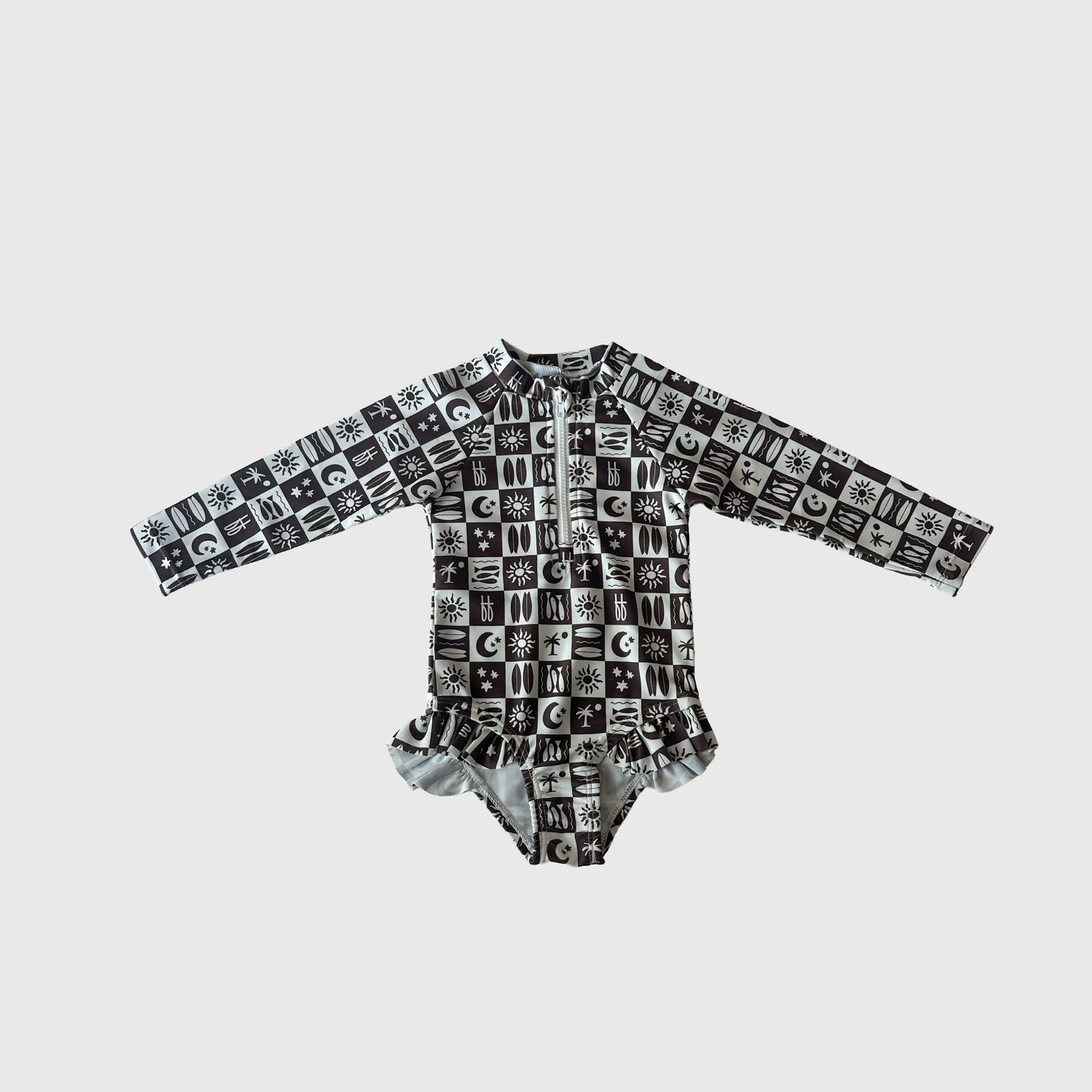 The Girl's Long Sleeve Swimsuit | Summer Check by forever french baby features a black and white grid pattern with sun, moon, and star symbols plus a ruffled waist—an adorable swim-ready outfit for kids.