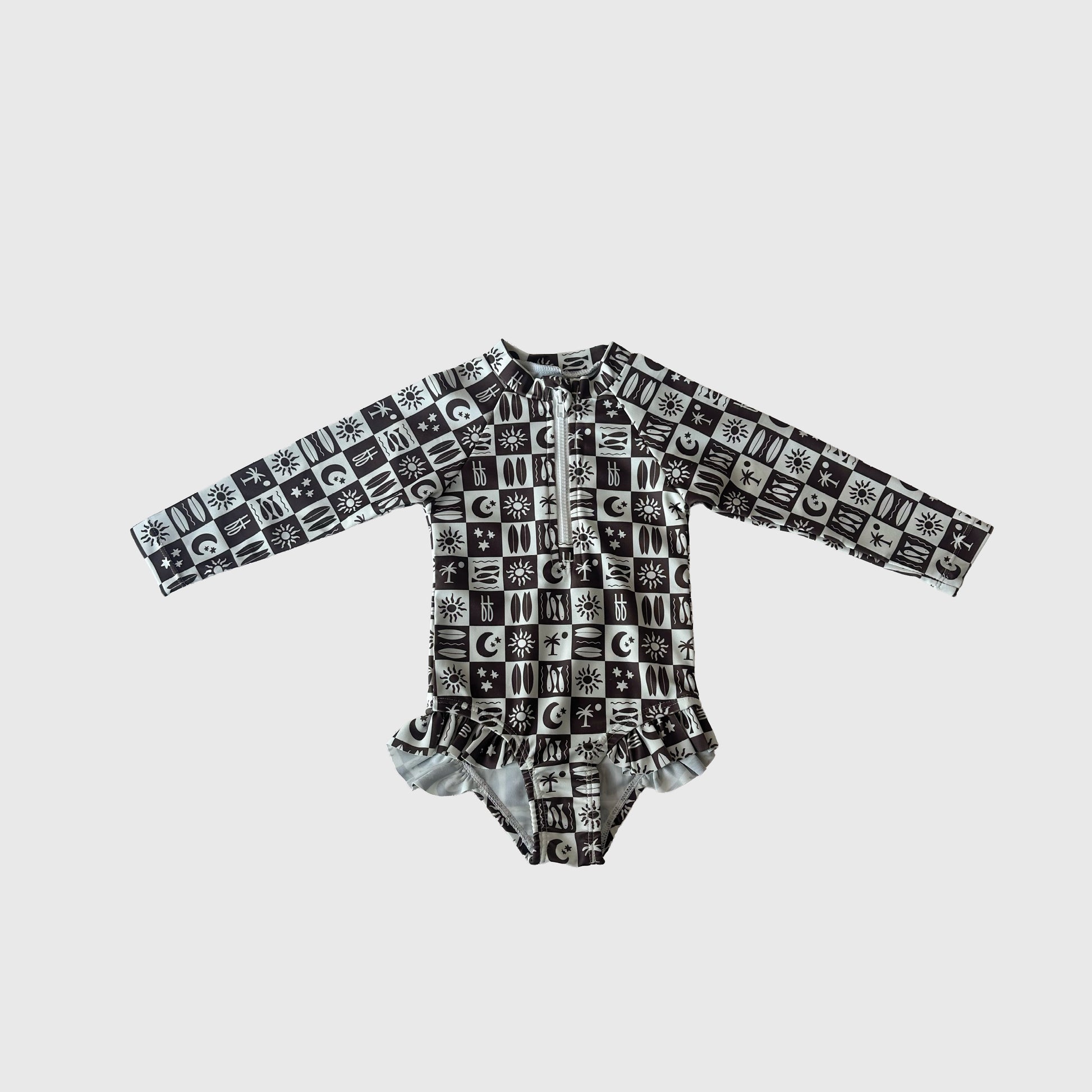 The Girl's Long Sleeve Swimsuit | Summer Check by forever french baby features a black and white grid pattern with sun, moon, and star symbols plus a ruffled waist—an adorable swim-ready outfit for kids.