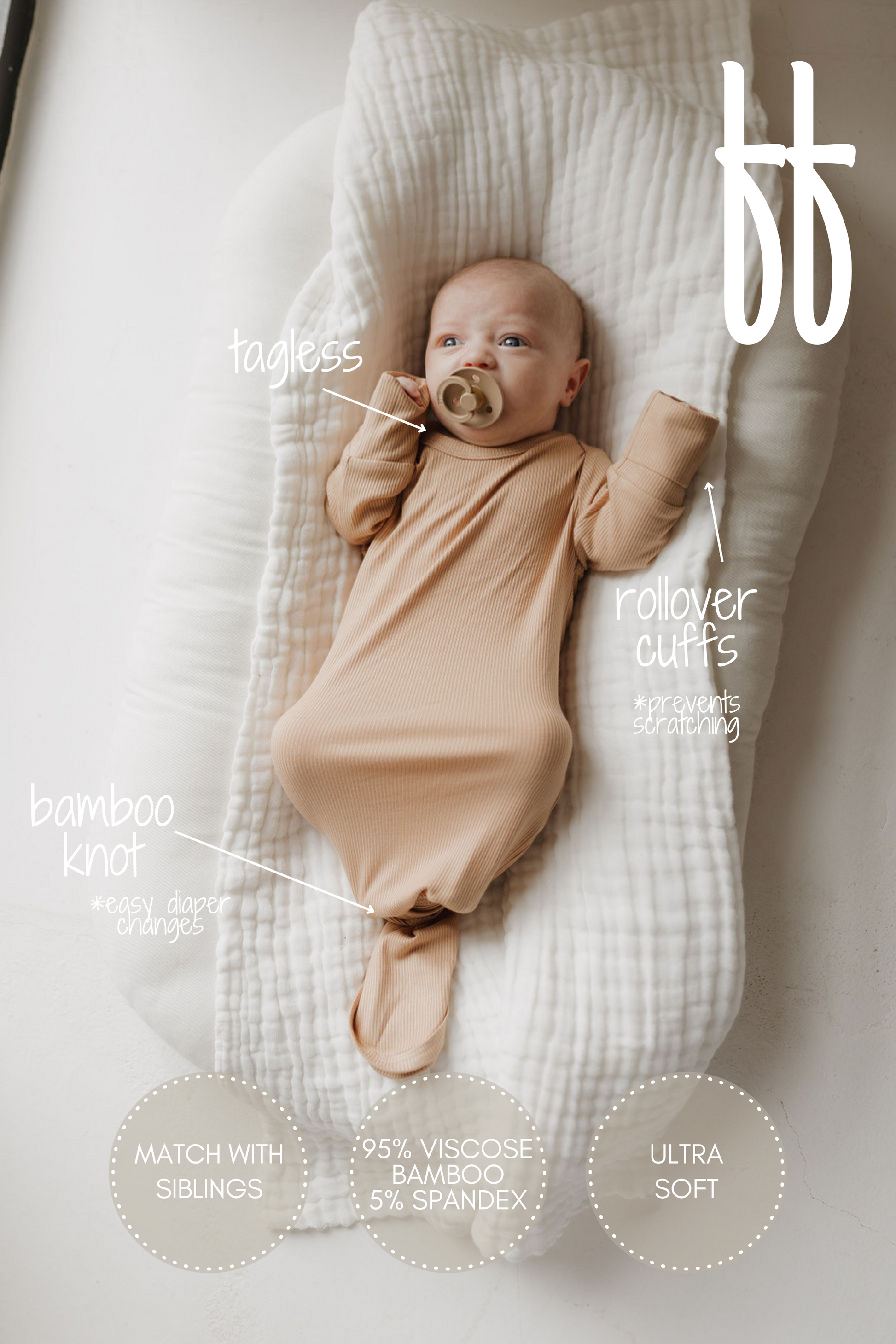 A baby in a tan Bamboo Knotted Gown | Tawny from forever french baby rests with a pacifier on a cushioned pad. This essential features a tagless design, rollover cuffs, and bamboo knot for easy changes, crafted from hypo-allergenic fabric (95% viscose, 5% spandex) for ultra-soft comfort.