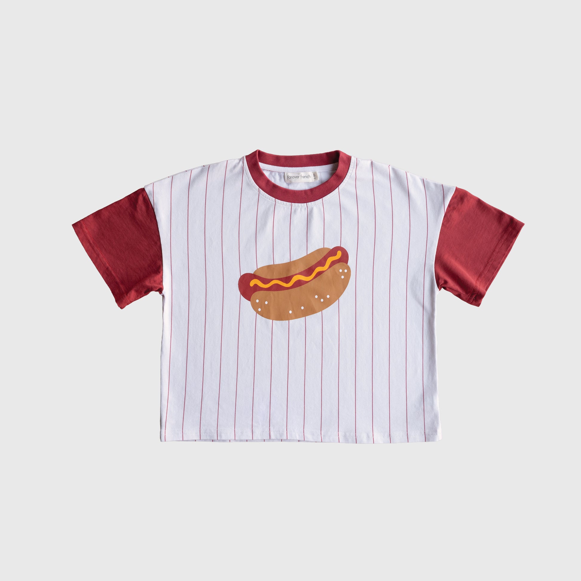 The forever french baby Child Cotton Tee | Hot Dogs features maroon sleeves and collar, thin maroon stripes on white, plus a playful hot dog with mustard—ideal for kids’ matching outfits or anyone who loves a unique hot dog t-shirt.