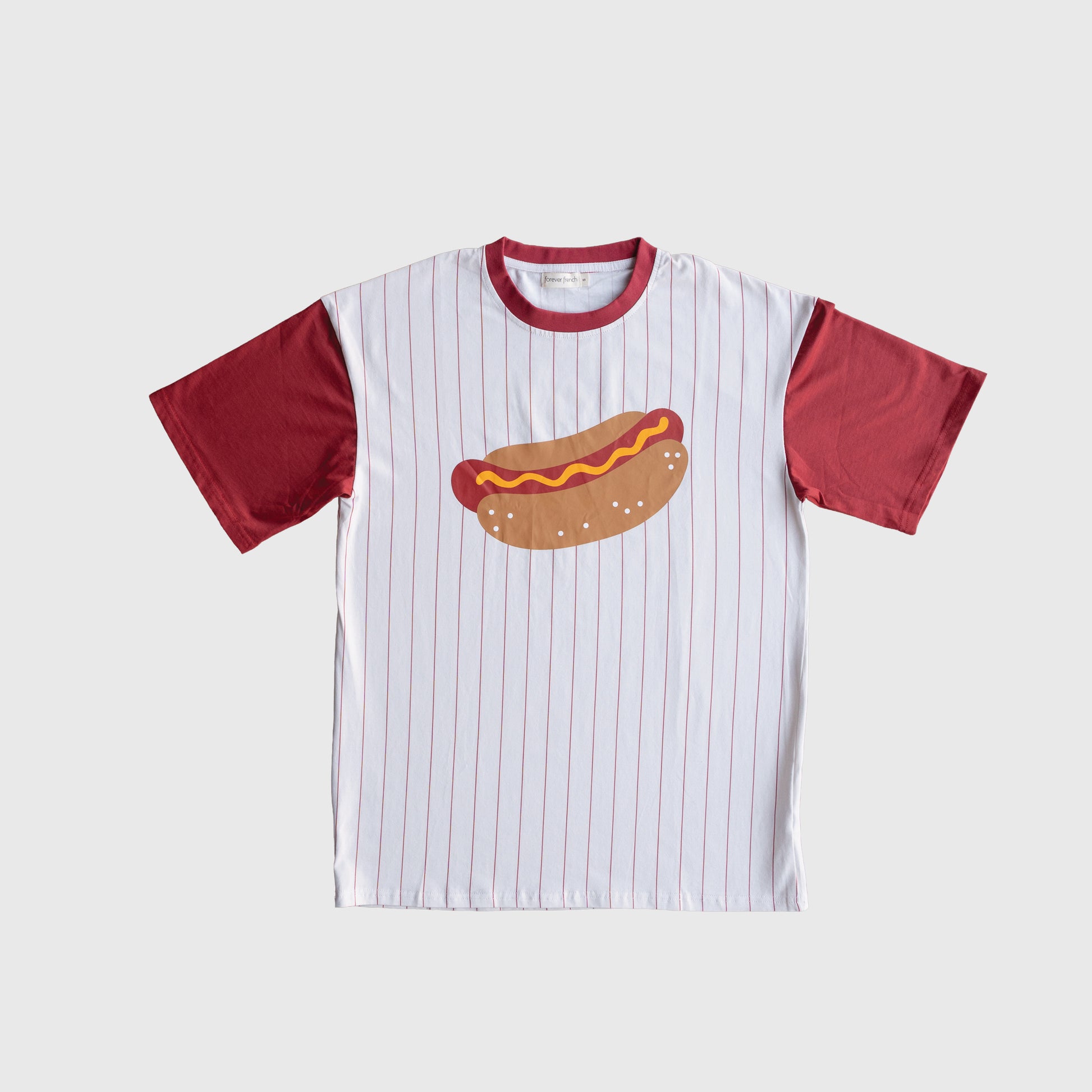 The forever french baby Adult Cotton Tee | Hot Dogs is a white cotton-spandex shirt with thin red stripes, red sleeves and collar, and a bold hot dog graphic with mustard and ketchup on the front.