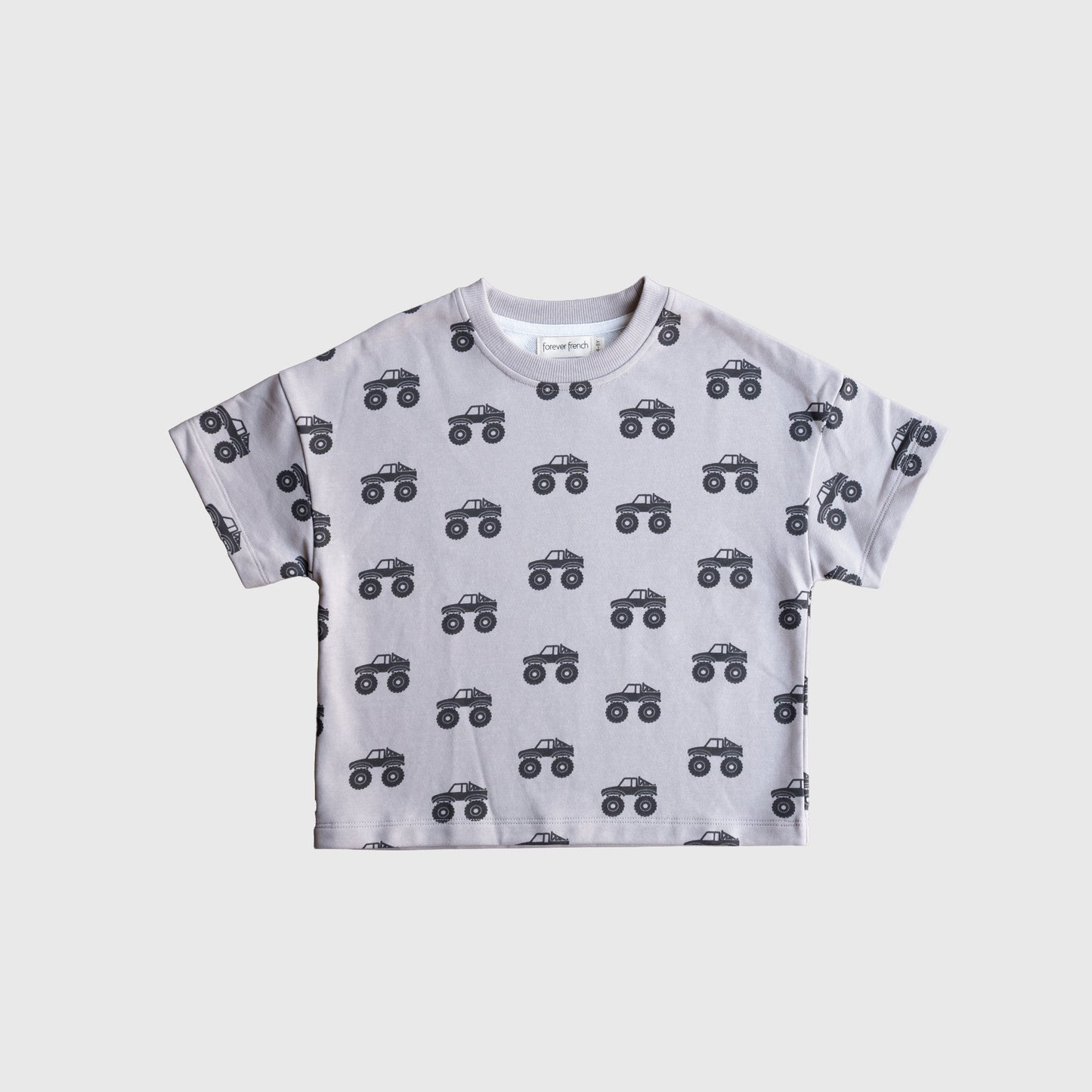 The forever french baby French Terry Short Set | Monster Truck features a light gray short-sleeved kids' tee with a playful black monster truck print, laid flat on white—ideal for everyday fun.