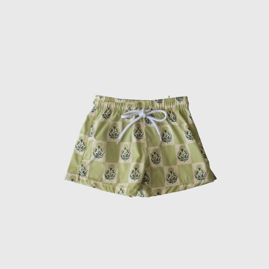 The forever french baby Child Board Short in Marigold Check features a light green checkerboard pattern with darker floral designs, white drawstring, and elastic waistband. Perfect summer wear for kids, shown on a plain white background.