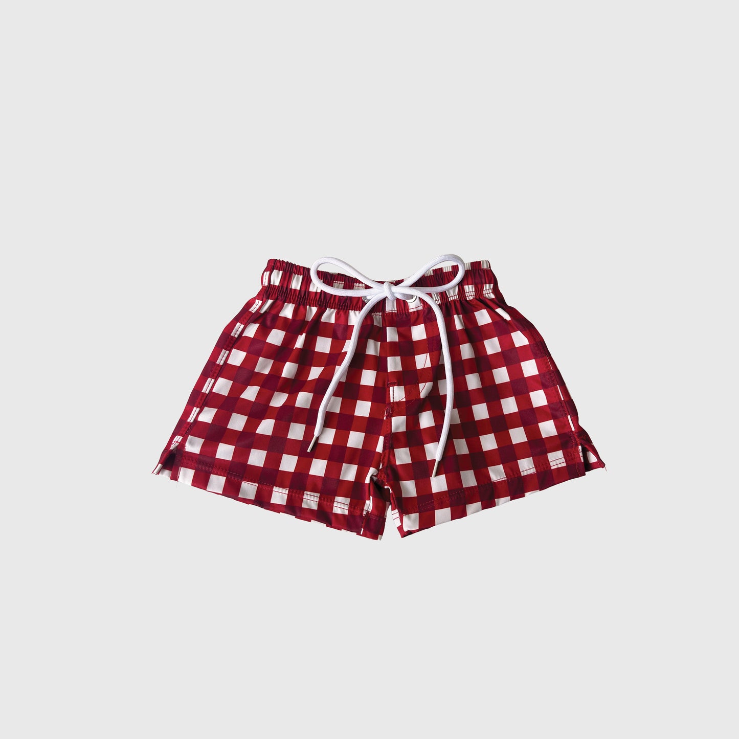 The forever french baby Child Board Short | Scarlet Gingham features a red and white checkered pattern, elastic waistband, and white drawstring—ideal for family matching—all set against a plain white background.