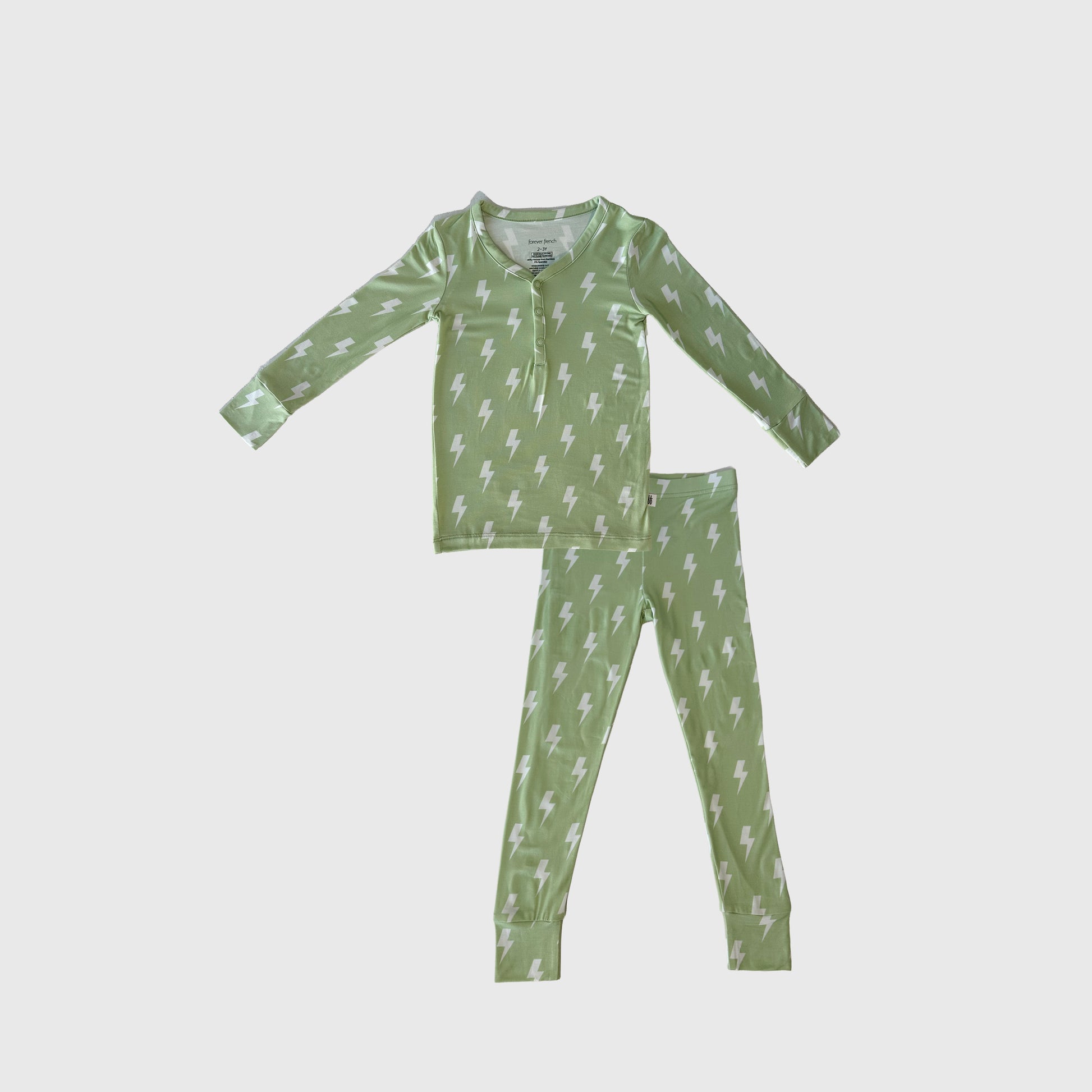 The Bamboo Two Piece Pajamas | Flash by forever french baby is a green long-sleeve children's set with a white lightning bolt pattern, buttoned neckline, and matching pants, made from breathable bamboo fabric and shown on a plain white background.