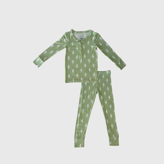 The Bamboo Two Piece Pajamas | Flash by forever french baby is a green long-sleeve children's set with a white lightning bolt pattern, buttoned neckline, and matching pants, made from breathable bamboo fabric and shown on a plain white background.