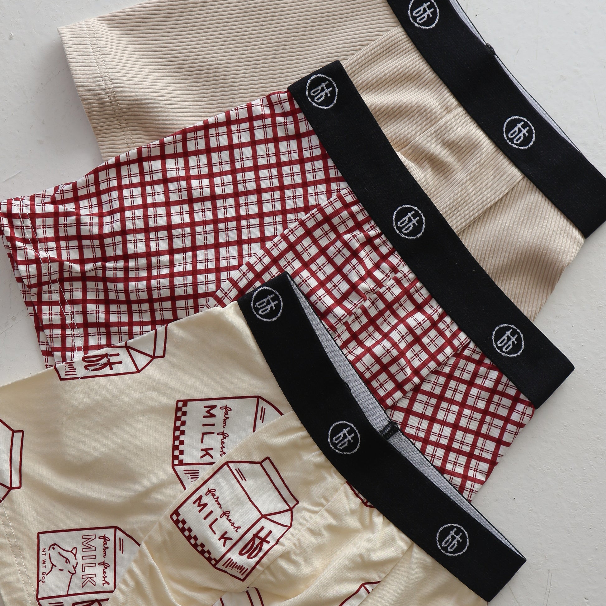 Forever french baby's Bamboo Boxers (3 Pack) feature men's boxers with black waistbands in ribbed cream, window pane plaid, and milk carton print designs.