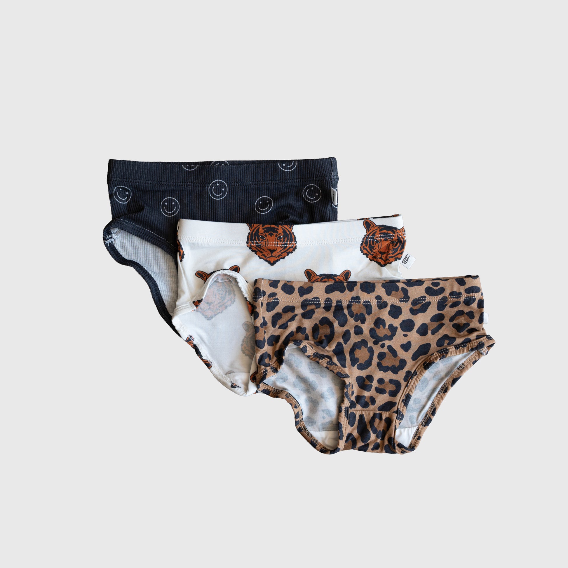 The forever french baby Girl's Bamboo Briefs (3 Pack) includes hypo-allergenic girls’ briefs in leopard print, tiger face, and black with smiley designs.