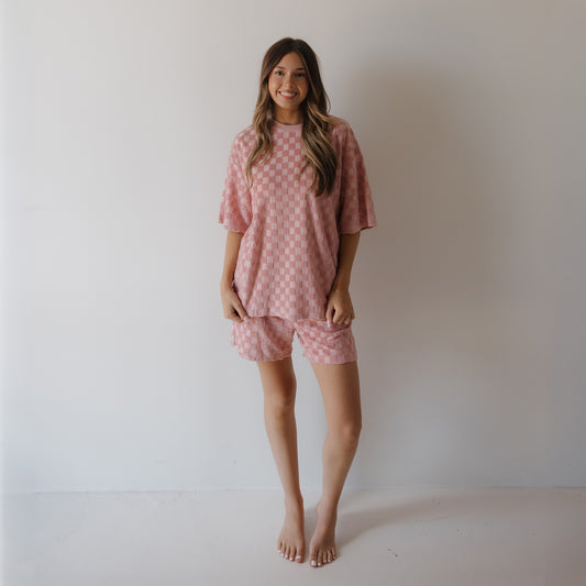 A woman smiles at the camera in the forever french baby Women's Terry Short Set in Sea Pink—an ultra-cozy lounge set perfect for relaxing or creating coordinated family matching outfits.