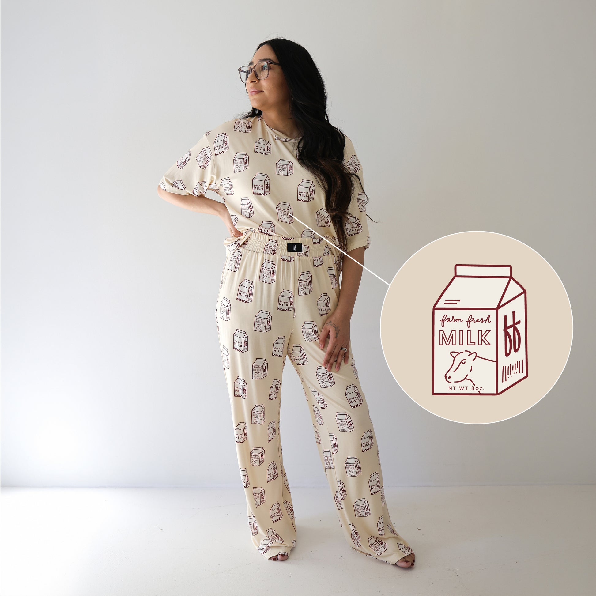 A woman models the forever french baby Women's Boxy Tee Lounge Set | Milk, a hypo-allergenic, cream lounge set with playful red milk carton prints, against a white background. Inset: close-up of the unique design on the pajamas.