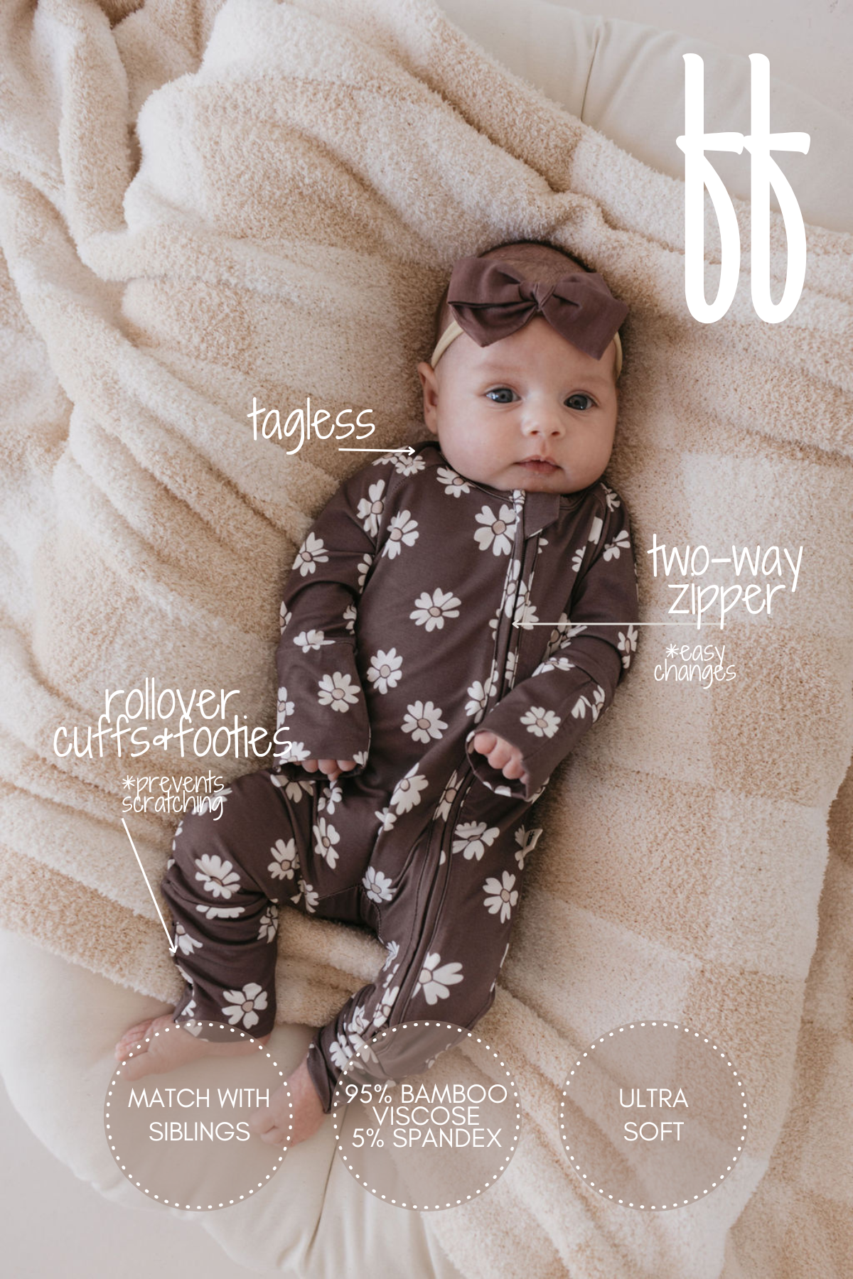 A baby is pictured wearing the "Midnight Meadow" Bamboo Zip Pajamas by forever french baby, complete with a brown floral pattern and matching headband, lying on a textured cream blanket. Made from breathable bamboo fabric, the pajamas feature convenient two-way zippers, rollover cuffs, and cozy footies.