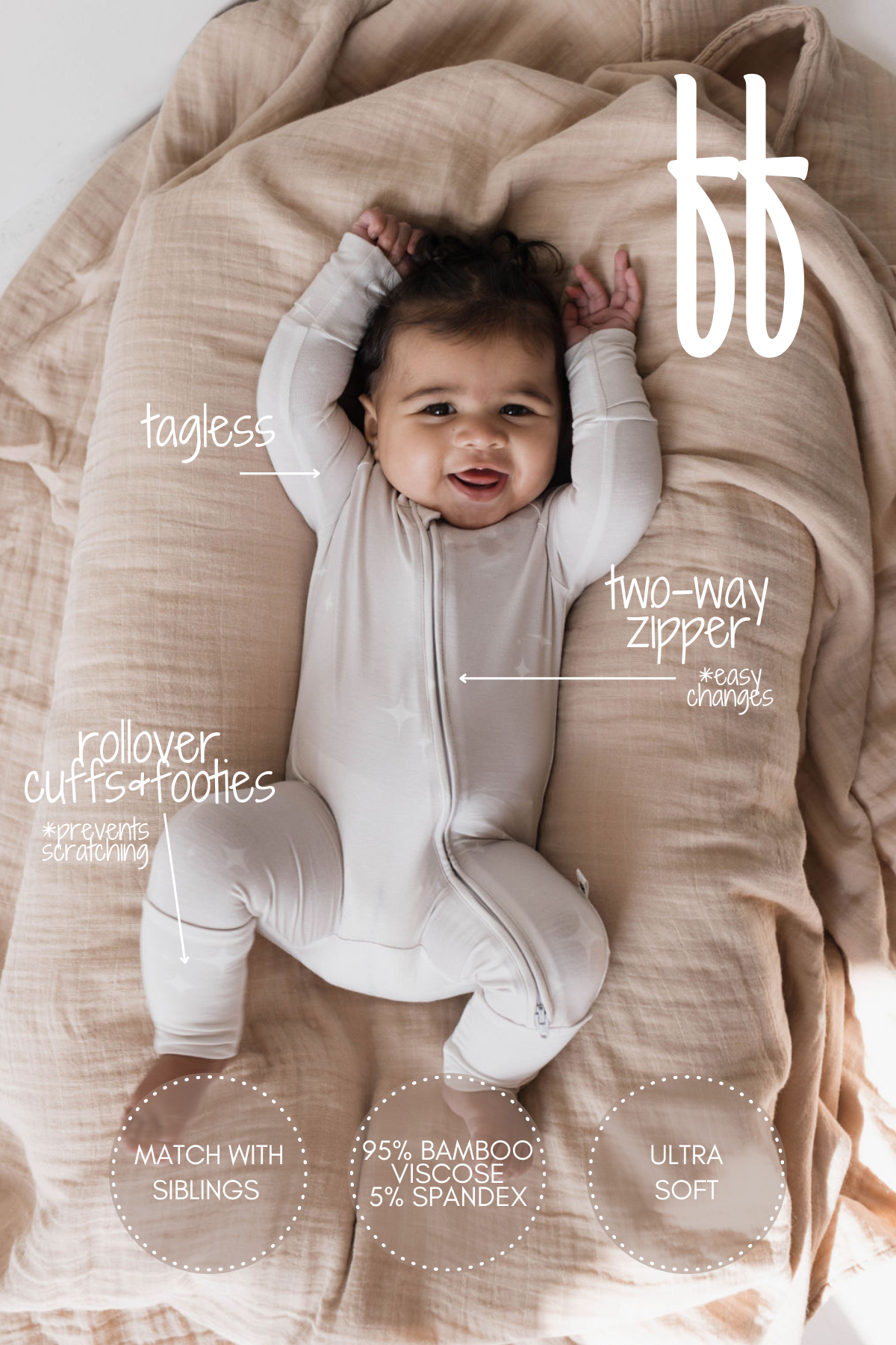 A smiling baby lies on a soft beige blanket, wearing the Sparkle! Bamboo Zip Pajamas from Forever French Baby. The light-colored onesie boasts features such as a tagless design, two-way zipper, rollover cuffs and footies, and is made of an ultra soft blend of 95% bamboo viscose and 5% spandex that is hypo-allergenic.