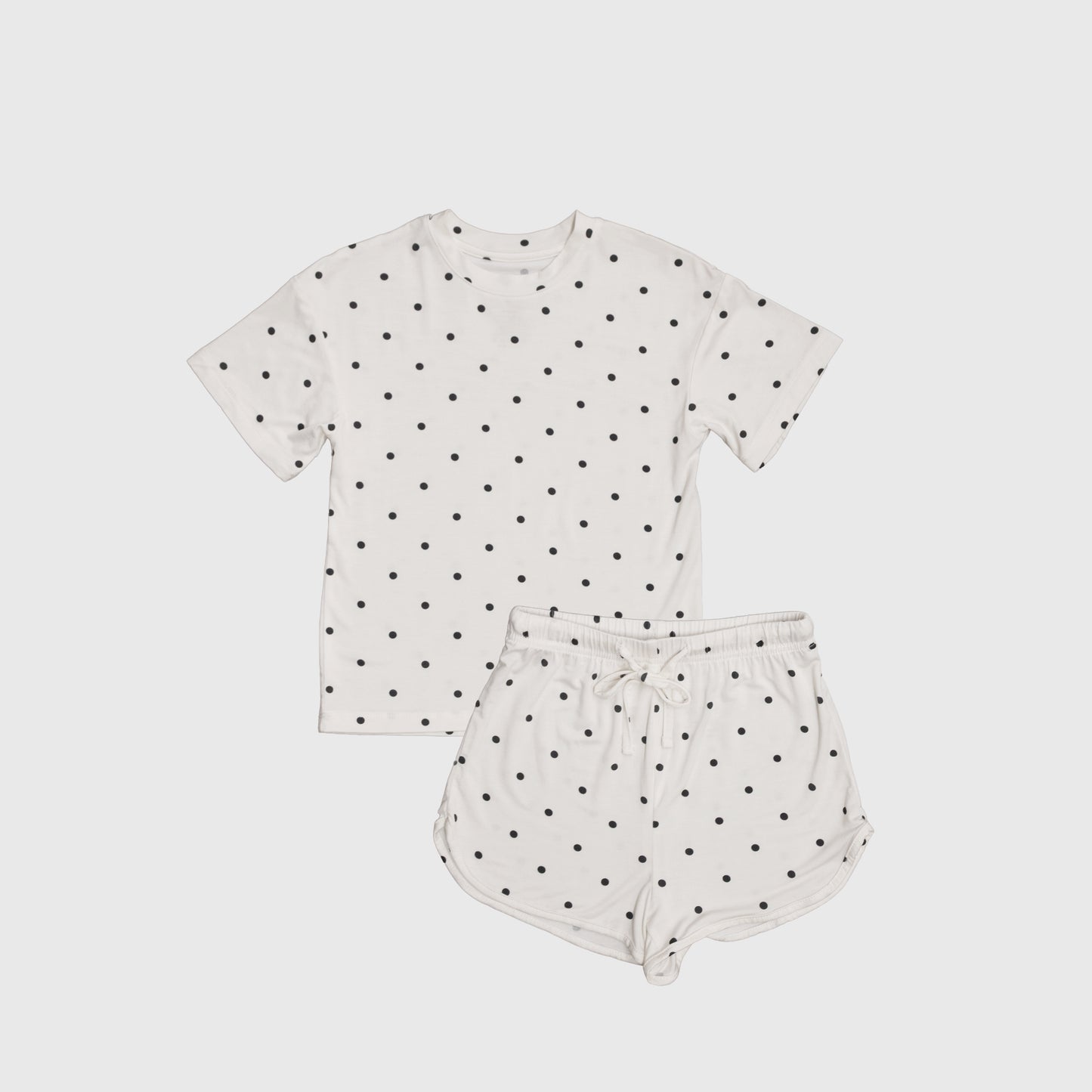 The Women's Bamboo Short Set | Annie by forever french baby features a white short-sleeve t-shirt and shorts with black polka dots, crafted from breathable bamboo set material and displayed flat on a white background.