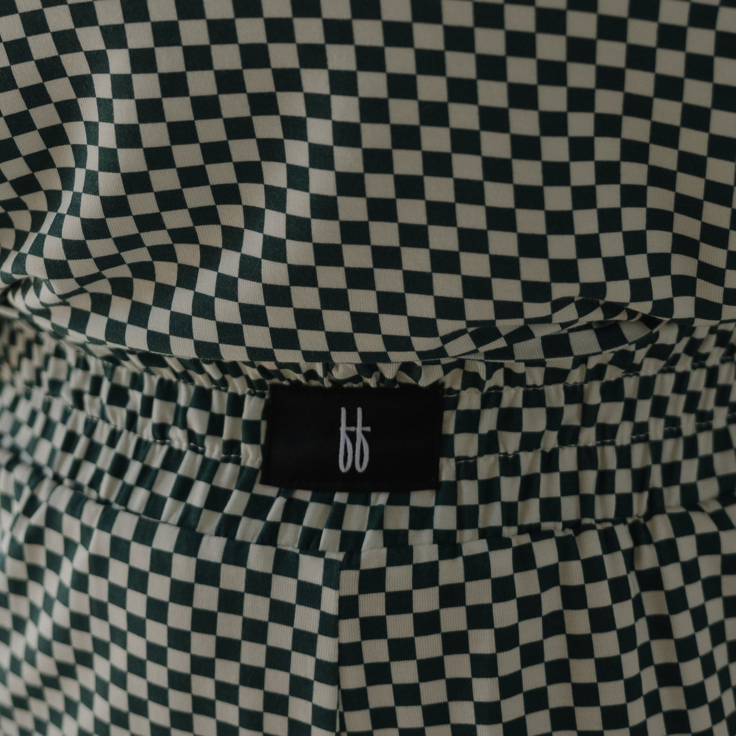 Close-up of the Women's Boxy Tee Lounge Set in Lucky Micro Check by forever french baby, featuring a black and white checkered bamboo fabric, elastic waistband, and a black tag with a white minimalist "ff" logo.