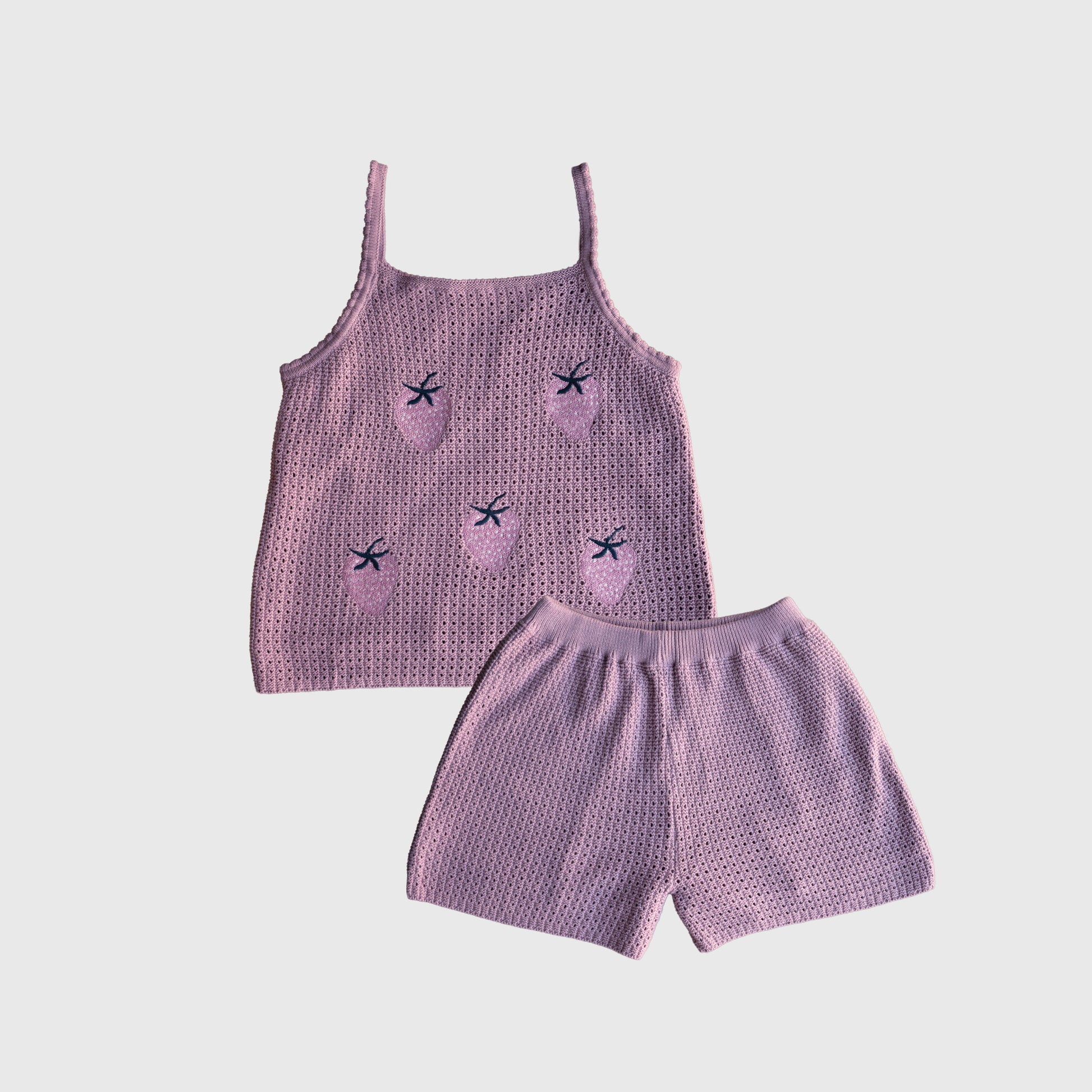 Sure! Here’s a rewritten sentence using the provided product data: The Women's Knit Short Set "Matilda" by forever french baby is crafted from 100% cotton knit fabric, featuring a lavender tank top adorned with pink strawberry designs highlighted by black star-shaped seeds and matching shorts. The set is displayed on a white background.
