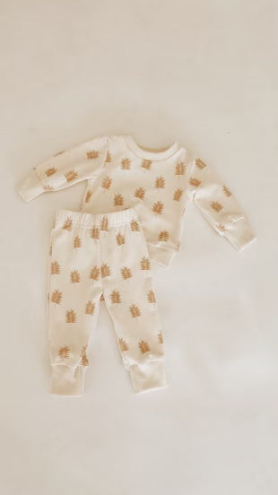 Part of the Just Smile Collection, the Palm Sweater Set by forever french baby is a two-piece baby outfit featuring a long-sleeve shirt and pants. The fabric is white adorned with small brown hedgehogs on a plain background.